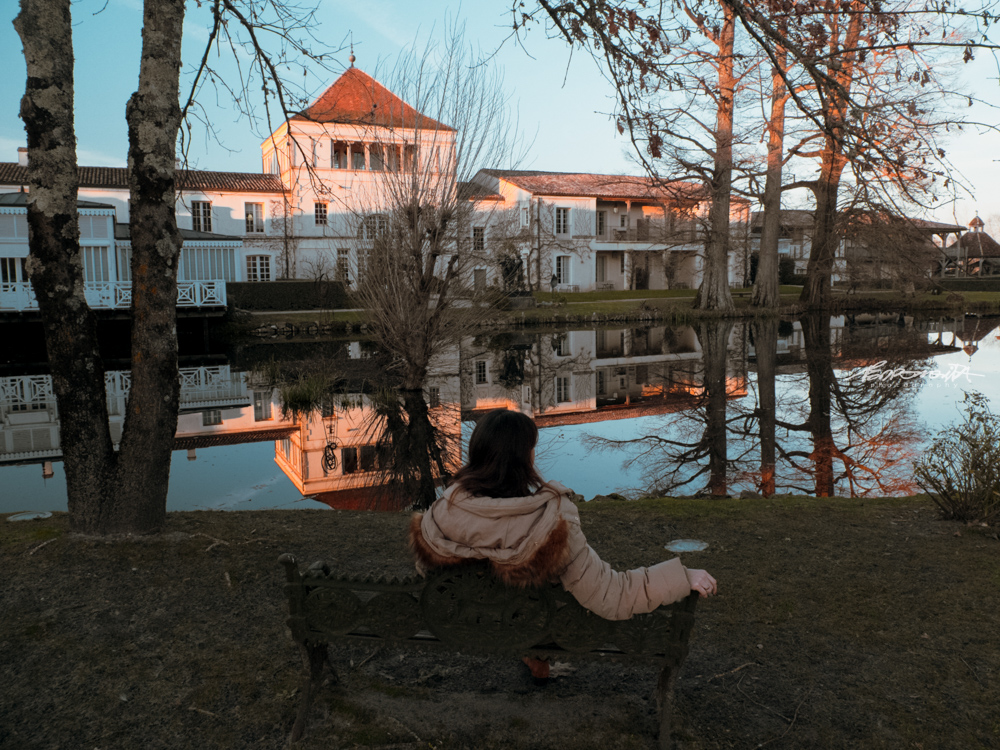 mulher sentada junto ao lago ao pôr do sol em Bordéus