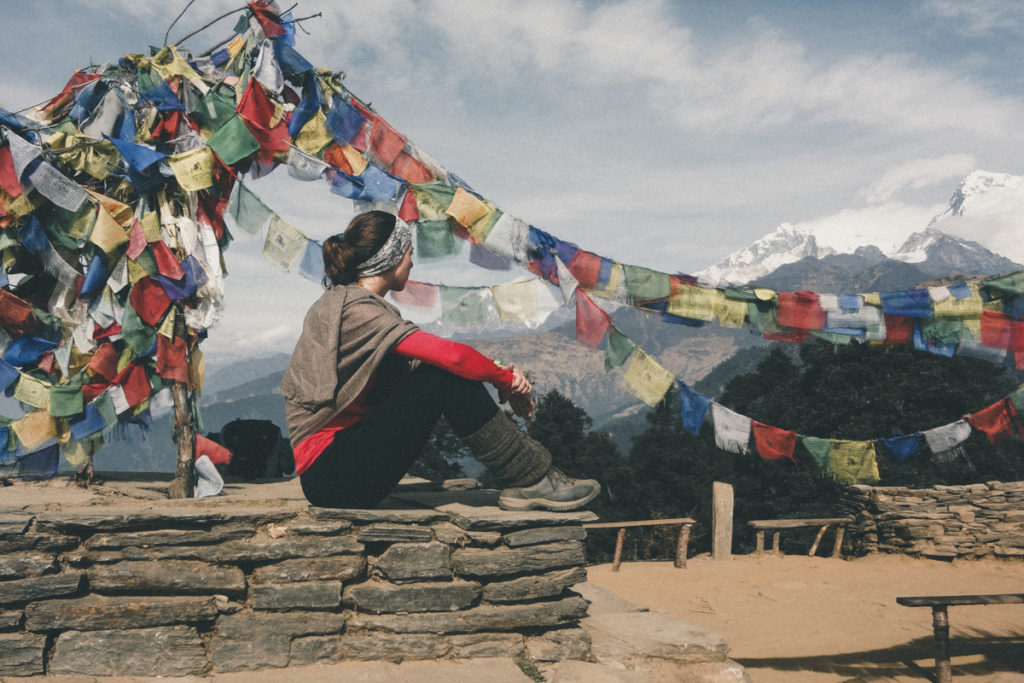 Mulher sentada num muro no Nepal