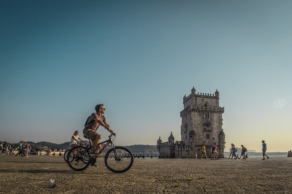 homem de bicicleta na torre de belem