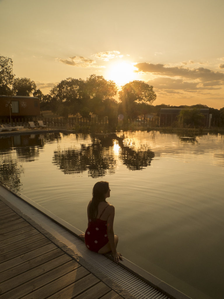 mulher em piscina biológica ao pôr-do-sol. turismo alentejo
