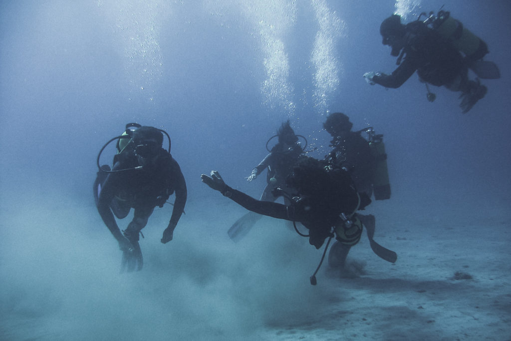 4 mergulhadores no fundo do mar