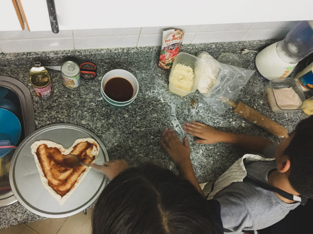 Mãe e filho na cozinha a fazerem pizza